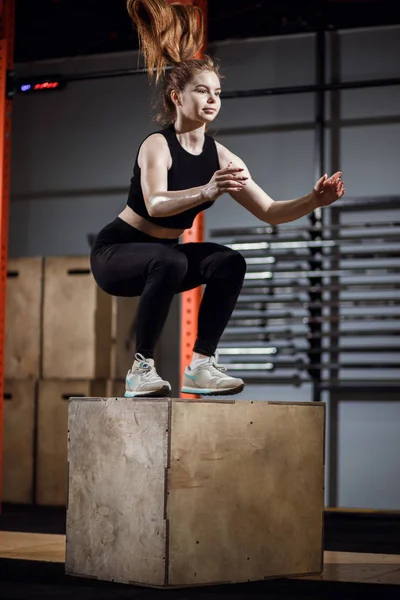 Подходит молодая женщина, прыгающая в тренажерном зале для кросс-фита — стоковое фото