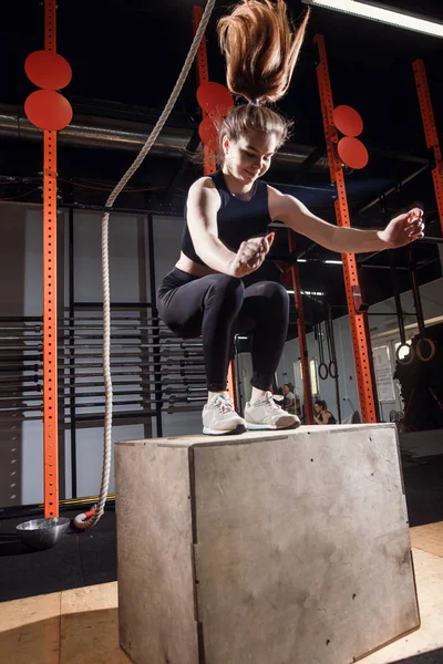 Fitness donna che salta sul box training in palestra, cross fit esercizio — Foto Stock