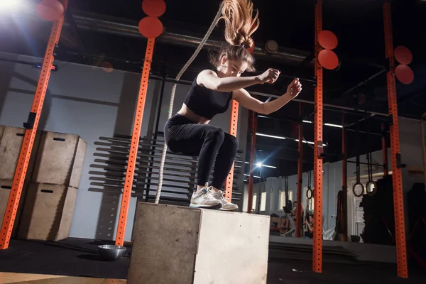 Fit young woman box jumping at a cross fit gym — Stock Photo, Image