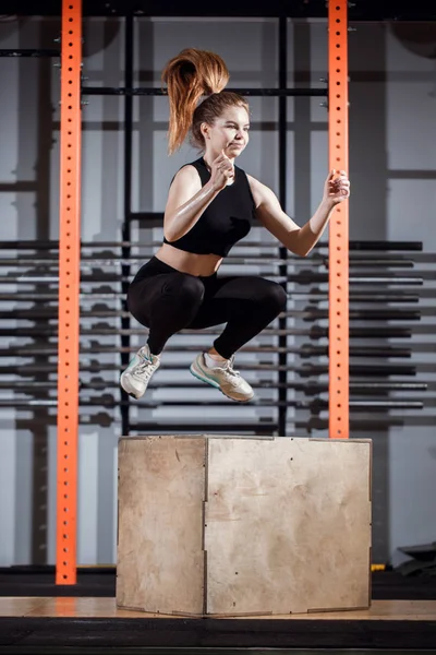 Fit young woman box jumping at a cross fit gym — Stock Photo, Image