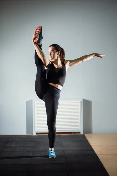 Sports. Woman at the gym doing stretching exercises and smiling on the floor — Stock Photo, Image