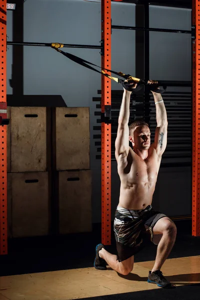 Férfiak során push ups képzés fegyver az edzőteremben trx fitness pántokkal — Stock Fotó