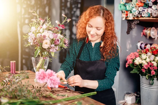 Mujer joven seleccionando flores en el mercado — Foto de Stock