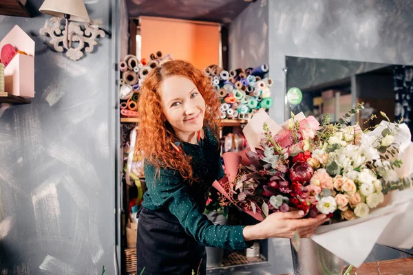 Aufnahme eines schönen Mädchens mit schönen Blumen bei der Arbeit — Stockfoto
