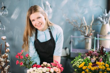 çiçek kompozisyon sunan giden ve mutlu satıcı