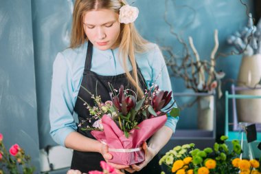 mavi arka plan üzerinde displasing çiçekler genç çiçekçi