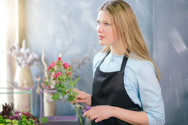 Mujer pensando en la decoración floral y sonó de colores en la tienda de flores — Foto de Stock