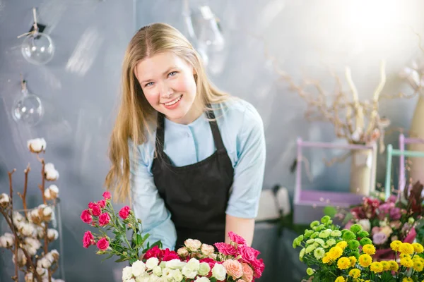 Foto de floristería agradable y amable sosteniendo florero de flores — Foto de Stock