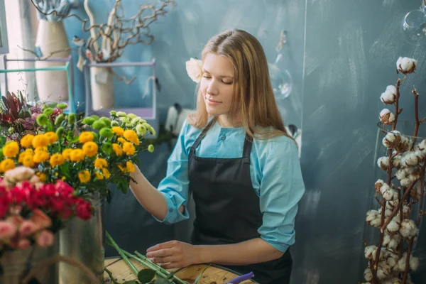 Nice female choosing fresher mimosas for bouquet indoors — Stock Photo, Image