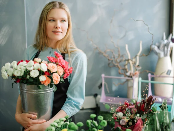 Foto einer attraktiven Frau mit Blumen auf dem Arm — Stockfoto