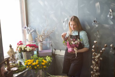 duvarın önünde duran ve atflowers seyir sarışın kız