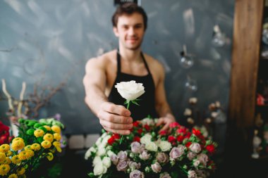 görüntü, satıcının alıcıya beyaz gül sunulması