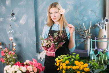 farklı çiçekler arasında duran ve kompozisyon tutan genç kadın