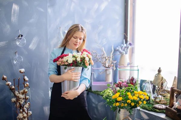 Chica romántica con flores frescas de pie sobre el fondo gris —  Fotos de Stock