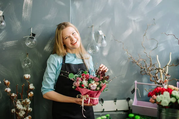 Blont florist leende till kamera och vila på jobbet — Stockfoto