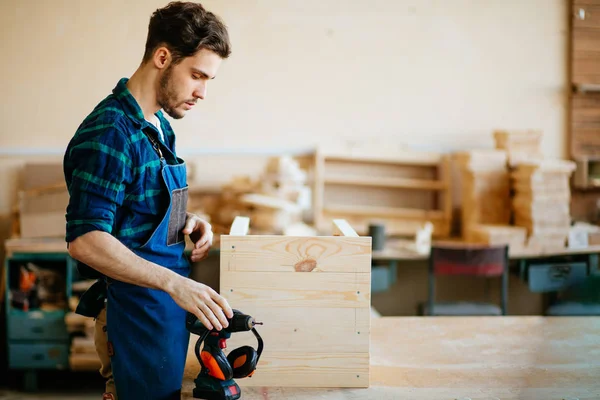 Junge Tischlerin schaut in Werkstatt in die Kamera — Stockfoto