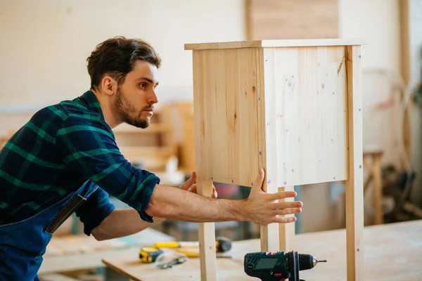 Timmerman testen houten plank gelijkmatigheid op workshop — Stockfoto