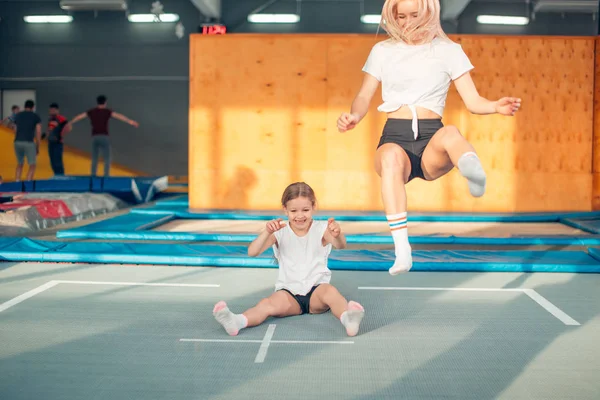 Moeder en dochter springen op de trampoline en split doen — Stockfoto