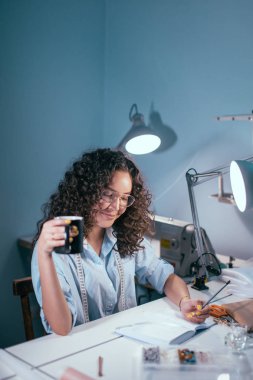 el odasındaki masada oturan kupa ile güzel terzi