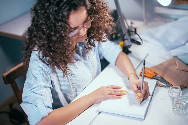 Closeup bijgesneden foto van kant weergeven van naaister schrijven nota's in dagboek — Stockfoto