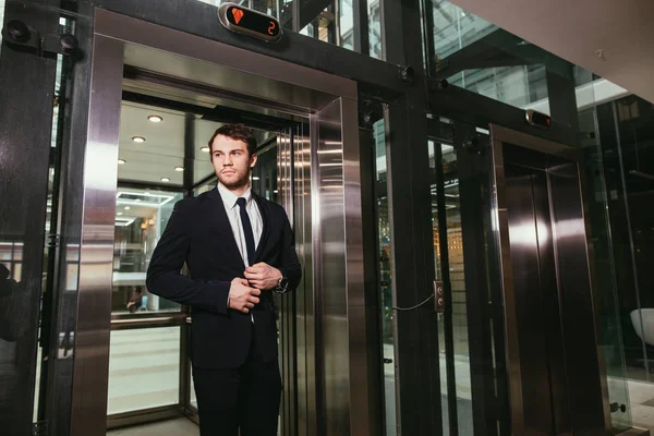 Hombre de negocios de mediana edad con maletín que sale del ascensor — Foto de Stock
