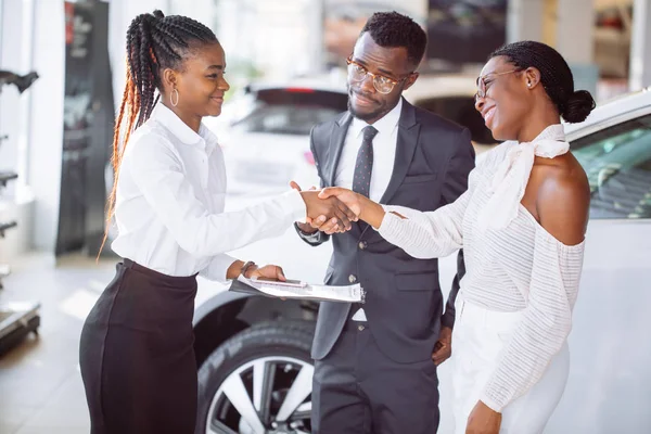 Cliente a comprar um veículo na concessionária de automóveis. mulher e homem aperto de mão — Fotografia de Stock