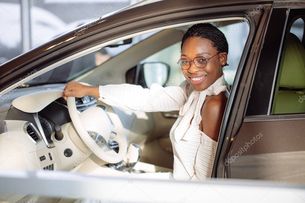 cheerful african female driver inside car