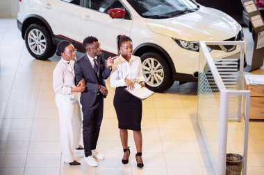 Araba özellikleri hakkında müşteriler için söylüyorum galerisinde duran araba satıcısı