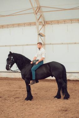 üzerinde kahverengi bir binicilik tişörtlü adam