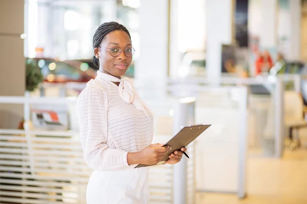 Commerciante professionista femminile che lavora nella concessionaria di auto — Foto Stock