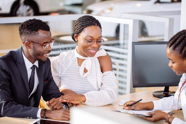 Ευτυχισμένο ζευγάρι Αφρικής με έμπορο που αγοράζουν αυτοκίνητο δείχνουν auto ή σαλόνι — Φωτογραφία Αρχείου