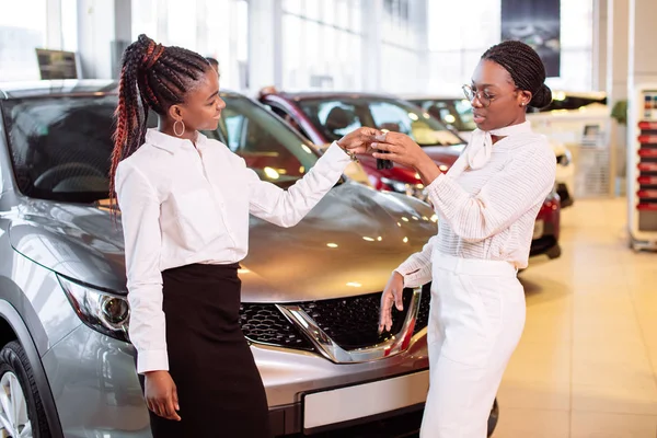 Duas afro-americanas perto de carro com chaves na mão conceito de compra de carro — Fotografia de Stock