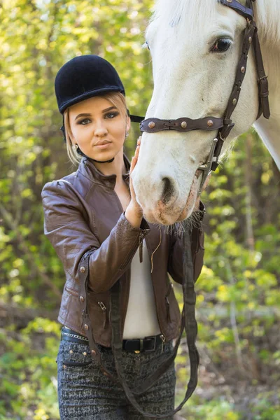 Beautiful girl stroking horse outside — Stock Photo, Image