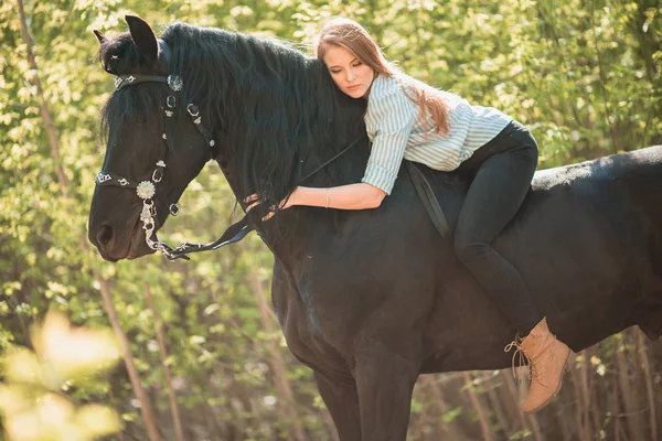 Menina jovem piloto com cabelos longos deitado no pescoço do cavalo — Fotografia de Stock