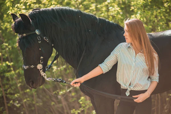 Krásná brunetka s dlouhými vlasy pózuje s červeným koněm v lese — Stock fotografie
