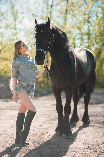 Hermosa chica morena con el pelo largo posando con un caballo rojo en el bosque — Foto de Stock