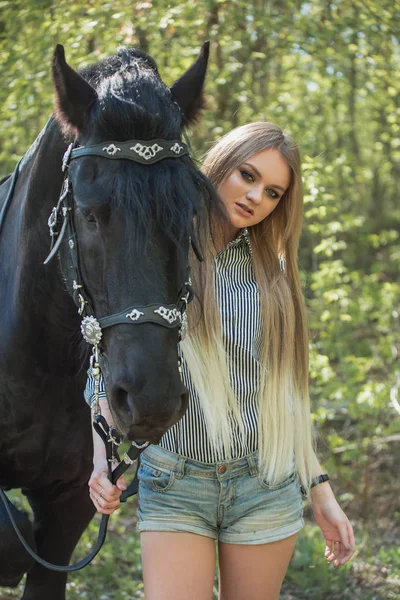 Piękna brunetka dziewczyna z długimi włosami pozowanie z czerwonym konia w lesie — Zdjęcie stockowe