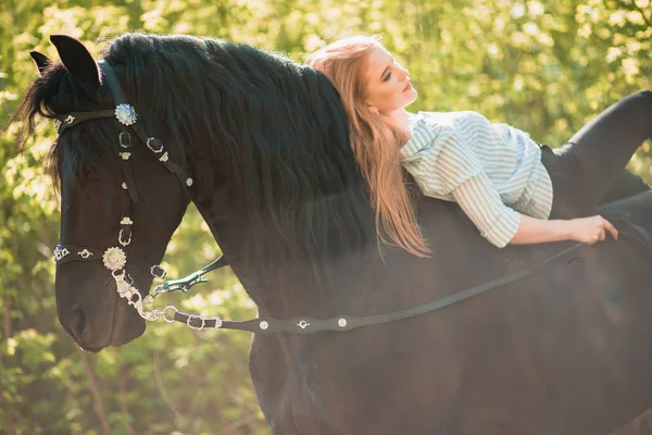 Jongere meisje met lang haar, liggend op de hals van het paard — Stockfoto