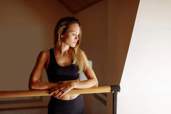 Žena tanečnice lodě poblíž barre v baletní studio. — Stock fotografie