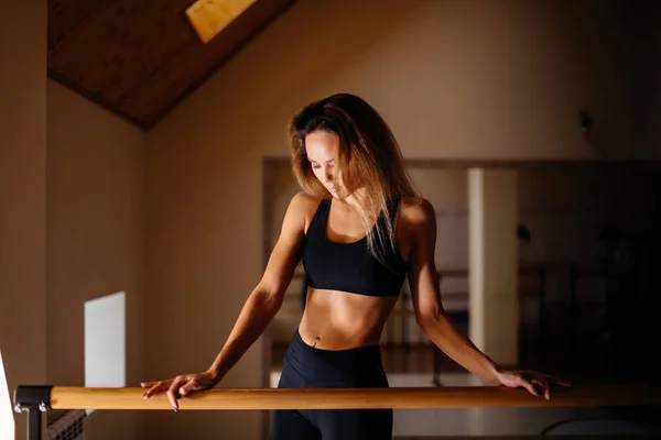 Танцовщица позирует возле Барре в балетной студии . Лицензионные Стоковые Фото