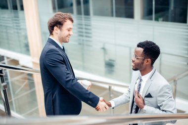 iki çok ırklı işadamları el sıkışma büyük sonu için modern ofis