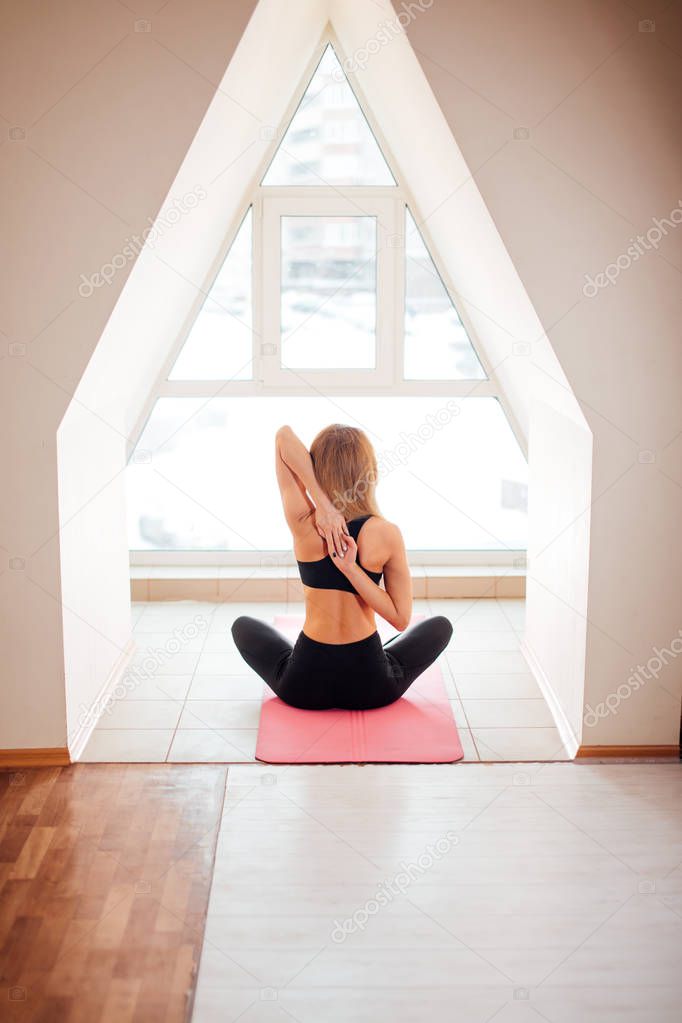Fitness female holding hands behind their back and stretching