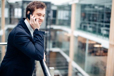 Çalışmak için yolda cep telefonunda konuşurken yürüyüş iş adamı