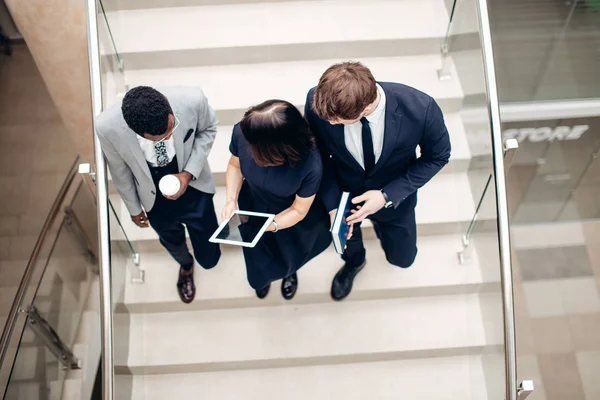 デジタル タブレットで階段を歩いて 3 つの多民族のビジネス人 — ストック写真