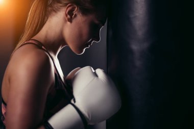 fighter girl in gym with boxing bag. Long hair woman fitness model clipart