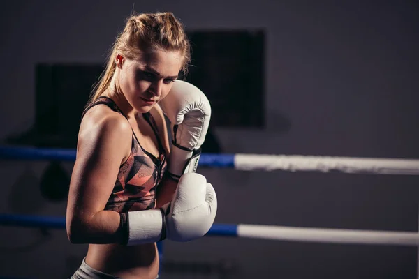 Female Boxer wearing gloves posing in boxing studio — Stock Photo, Image