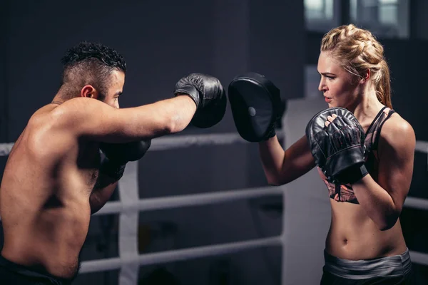 Sportlicher muskulöser junger Mann und Frau boxen vereinzelt auf schwarz — Stockfoto