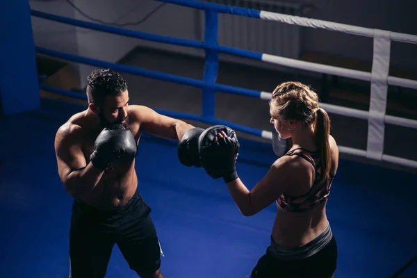 Boxmädchen beim Training an Boxhandschuhen, die von einem Meisterboxer gehalten werden — Stockfoto