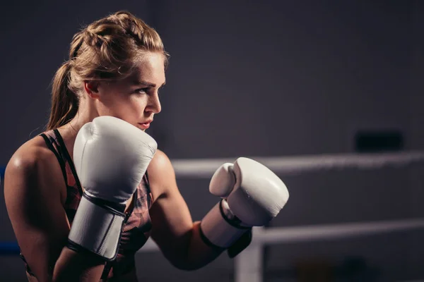 Boxeadora con guantes posando en estudio de boxeo — Foto de Stock