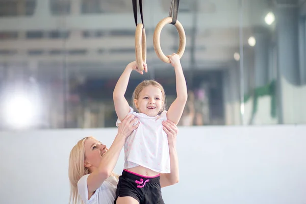 Mor hjälpande dotter att idrotta på Gymnastringar — Stockfoto